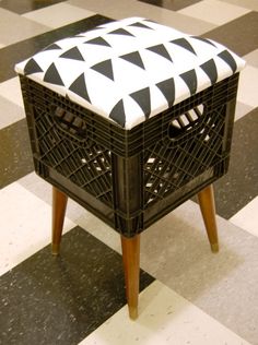 a black and white ottoman sitting on top of a checkered floor