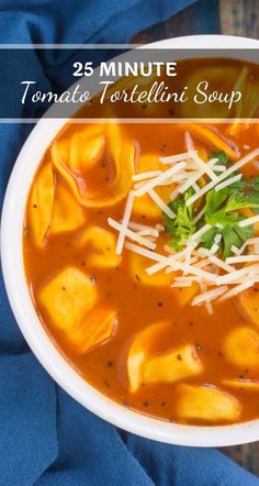 a white bowl filled with tortellini soup and topped with parmesan cheese