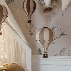 several hot air balloons are hanging from the ceiling in this child's nursery room