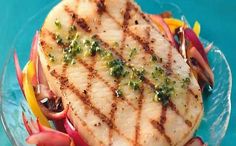 grilled fish and vegetables on a glass plate