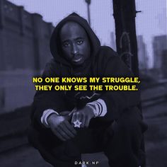 a man squatting on the ground in front of a train track with a quote above him