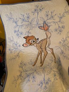 a quilted blanket with an image of a fawn and flowers on the back