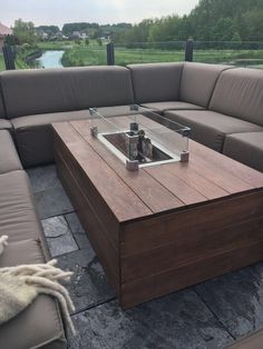 a couch with a coffee table on it in front of a large open area that looks out over the water