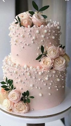 the cake is decorated with flowers and pearls