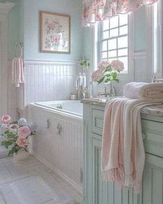 a bath room with a tub a sink and flowers