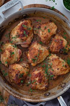 a pan filled with meat and sauce on top of a table