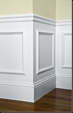 an empty room with white walls and wood floors