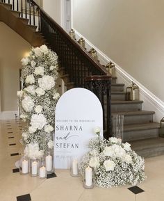 wedding decorations on the floor in front of stairs with candles and flowers next to it