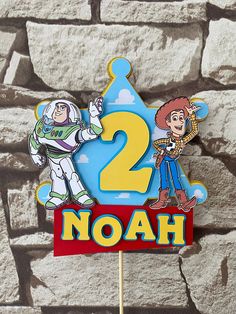 a toy story birthday cake topper with two characters on it and the number 2