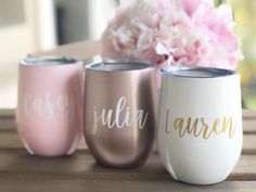 three personalized wine glasses sitting on top of a table next to a pink flower