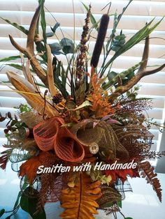 a vase filled with lots of different types of flowers and plants on top of a table