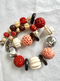 "Beautiful handmade artisan pieces of old French jewellery. Used multi material including carved galalith beads with 4 brown ceramic spacers, white little plastic spacers and some middle size wood beads. The galalith beads comes in cream white, angle sink pink and coral red colour. Caved, drilled and sculpted to very unique pieces. They have the pink and red coral look.  Vintage Art Deco Early Cast Plastic Faux Coral & Ivory Carve Bead Necklace  Beautifully old hand carved jewellery. A true collector's piece. Necklace length: 40cm.  There is 10cm extension chain. Strung on fish wire.  It has its original bronze spring ring clasp. In good vintage condition. There is a bit wearing on the two silver metal like beads, but can see the traces of time as  a 3D effect as well. No missing beads.  S Retro Wooden Beads Jewelry, Retro Wooden Bead Jewelry, Retro Wooden Round Bead Jewelry, Large Vintage Beads For Jewelry Making, Vintage Jewelry With Wooden Round Beads, Vintage Wooden Round Beads, Vintage Brown Jewelry With Spacer Beads, Handmade Retro Bakelite Jewelry, Vintage Wooden Beads For Jewelry Making