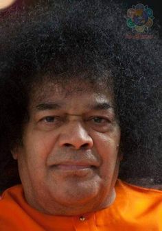 an old man with large afros wearing an orange shirt