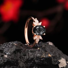 a black diamond ring sitting on top of a rock