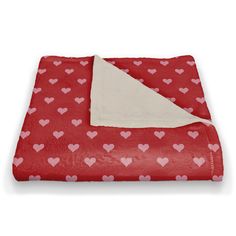 a red blanket with hearts on it and a white square in the middle is folded up