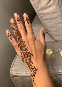 a woman's hand with henna tattoos on it