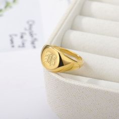 a gold signet ring sitting on top of a white box