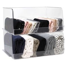 two clear acrylic shelves with folded towels and sweaters