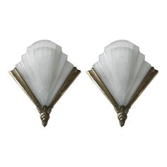 a pair of sconces with white glass shades