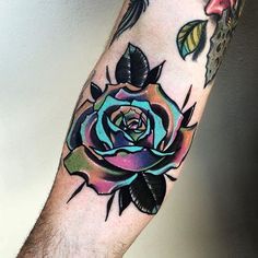 a man's arm with a colorful rose tattoo on it