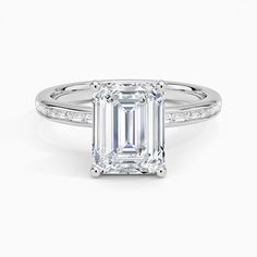 an emerald cut diamond ring with channeled shoulders