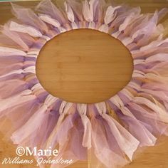 a pink tulle wreath on top of a wooden table