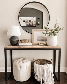 a table with two stools and a mirror on the wall next to it,