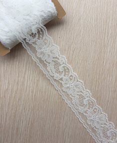 a roll of white lace sitting on top of a wooden table