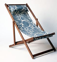 a blue and white patterned lawn chair with wooden frame, on a white background in the shape of a reclining chair