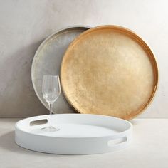 an empty wine glass sitting next to a metal platter and tray on a table