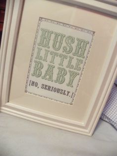 there is a cross stitch picture in the frame that says hush little baby no seriously