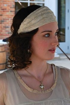 a woman wearing a headband and holding an umbrella