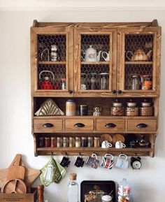 a wooden cabinet filled with pots and pans