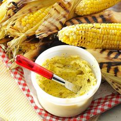 an image of corn on the cob with butter and mustard in a small bowl