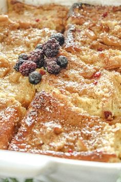 a casserole dish with berries and powdered sugar on top, ready to be eaten