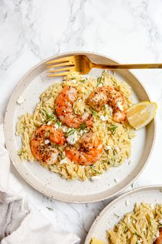 two plates with shrimp and pasta on them