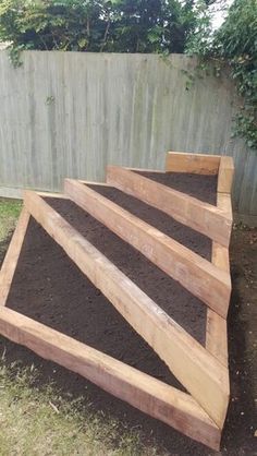 wooden steps made out of dirt in front of a fence