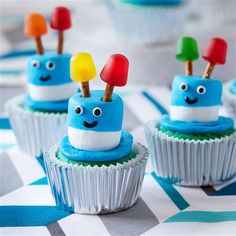 some cupcakes with blue frosting and colorful toppings on top of them