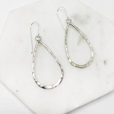 "These contemporary earrings consist of Sterling silver wire formed by hand into teardrops, and hammered to reflect the light beautifully. They are attached to a wire ear hook, which shows them off and ensures a lightweight dangle for every day wear.  - 50mm drop - quality ear-hook - hypoallergenic  - 925 Sterling Silver  - Hand Made Item The perfect pair to finish off your every day street style or minimalist wardrobe.  As you aware that each earring is forged by hand, therefore ever so slightly different from one another to give it an uniqueness about it.  Your earrings comes with a \".925\" sterling silver stamp as a symbol of guaranteed product quality as well as beautifully packaged in a branded box, ready for gifting, or spoiling yourself with a personalized piece. Free polishing clo Modern Nickel-free Sterling Silver Teardrop Earrings, Elegant Hammered Sterling Silver Teardrop Earrings, Modern Hammered Teardrop Jewelry, Minimalist Hammered Drop Earrings, Hammered Teardrop Earrings, Silver Hammered Teardrop Earrings, Hand-forged Teardrop Hoop Earrings, Modern Sterling Silver Teardrop Pendant Earrings, Hand Forged Silver Teardrop Earrings