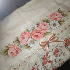 an embroidered blanket with pink roses and white daisies