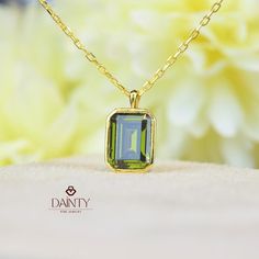 Peridot Necklace I 14K Solid Gold Peridot Pendant I Rectangle Bezel Necklace I May Birthstone Jewelry I Anniversary Gift I Christmas Gift Item Gemstone: AAA Grade Peridot Cubic Zirconia Size: 7*5 mm  Color: Green Shape: Emerald Cut  Average Quality: AAA+ This exquisite necklace features a captivating peridot stone, known for its vibrant green hue that exudes a sense of freshness and vitality. The peridot stone measures 7x5 millimeters, making it a perfect size to catch the eye without being overly ostentatious.  Cut into an elegant emerald shape, the stone is designed to enhance its natural brilliance and clarity. The emerald cut, known for its step-like facets, highlights the peridot's depth and rich color, creating a mesmerizing play of light and shadow. Encased in a sleek bezel setting, Fine Jewelry Green Rectangular Jewelry, Green Rectangular Necklace For Formal Occasions, Green Rectangular Fine Jewelry, Formal Green Rectangular Necklace, Rectangular Green Gemstone Jewelry, Green Rectangular Pendant Jewelry For Anniversary, May Birthstone Rectangular Gemstone Necklaces, Gold Peridot Jewelry With Emerald Cut, Green Birthstone Jewelry With Rectangular Pendant