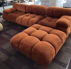 an orange couch sitting on top of a checkered floor