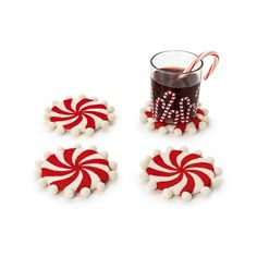 some candy canes are next to a cup of hot chocolate on a white background