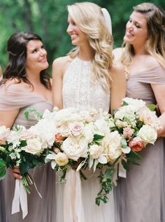 three bridesmaids holding bouquets in their hands