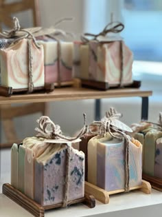 soaps are sitting on small wooden trays with twine bows tied around them