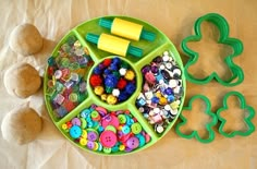 a child's play tray with plastic beads and buttons