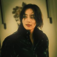 a woman with dark hair wearing a black leather jacket