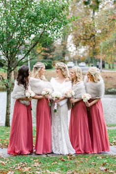 the bridesmaids are dressed in red dresses and fur stoles