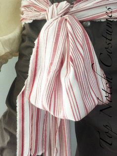 a red and white striped scarf tied to a mannequin