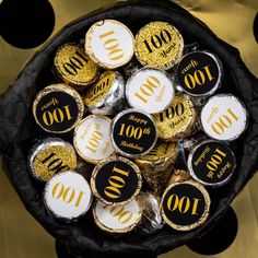 a bowl filled with lots of chocolate covered in gold and black confetti coins